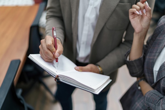 Gros plan d'un homme d'affaires debout au bureau et prenant des notes