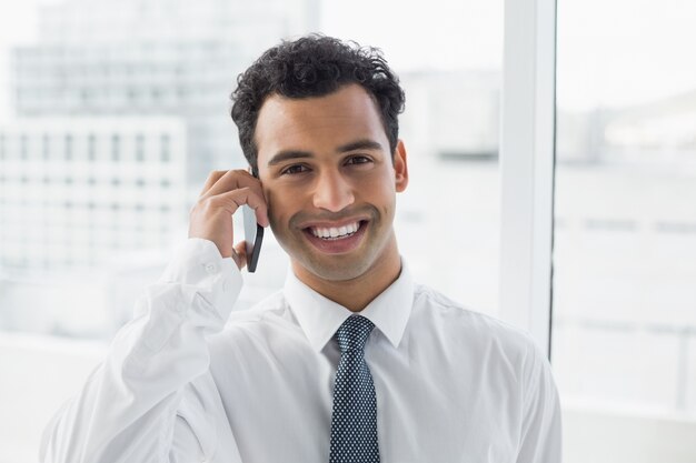 Gros plan d&#39;un homme d&#39;affaires élégant souriant à l&#39;aide de téléphone portable