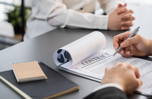 Gros plan homme d'affaires signe un contrat avec un stylo à la main Équilibre
