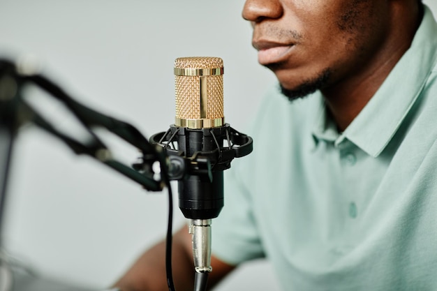 Gros plan d'un homme afro-américain parlant au microphone lors de l'enregistrement d'un podcast à la maison