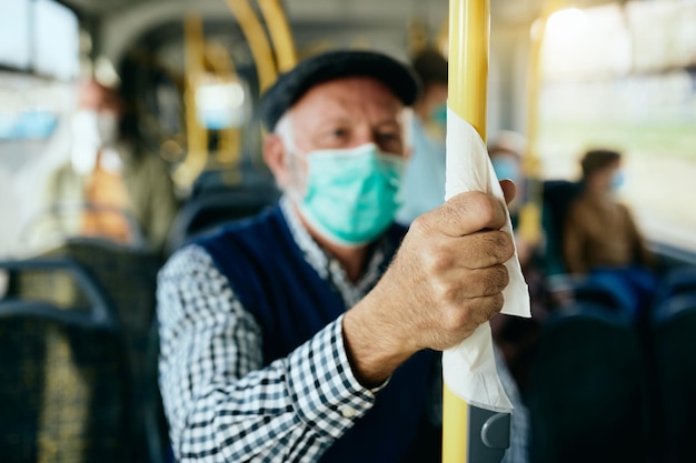 Gros plan d'un homme âgé se déplaçant en bus public pendant la pandémie de coronavirus