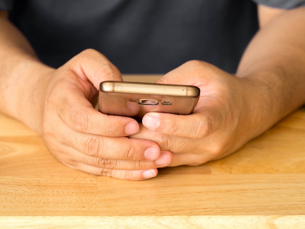 Gros plan d&#39;un homme à l&#39;aide de téléphone intelligent mobile. Un homme mains tenant le smartphone à écran tactile.