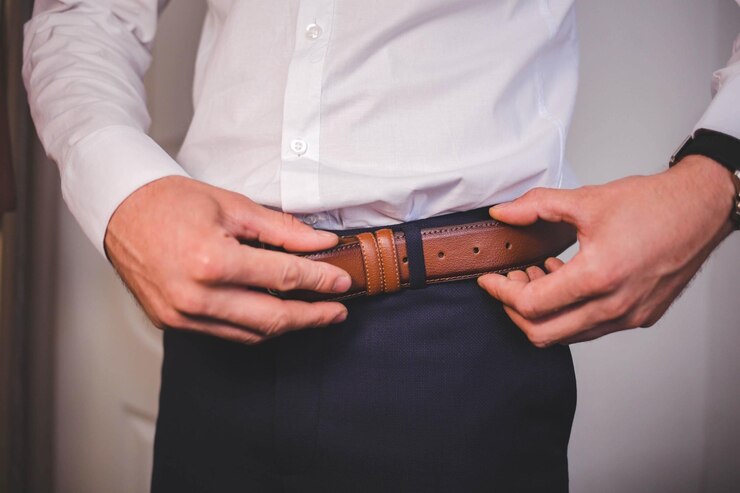 Photo gros plan d'un homme ajustant sa ceinture