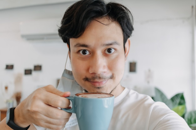 Gros plan d'un homme asiatique selfie lui-même boit du café chaud