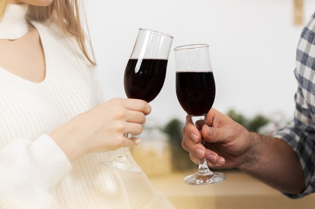 Gros plan d'un homme et d'une femme buvant du vin rouge