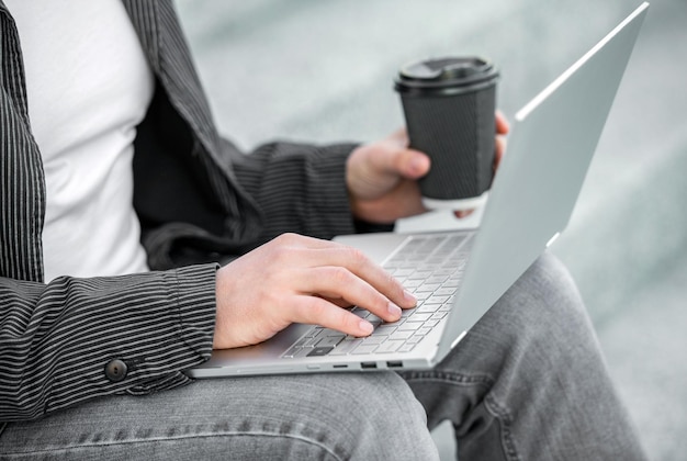 Gros plan d'un homme indépendant avec un café tapant la communication en ligne en ligne d'un homme indépendant