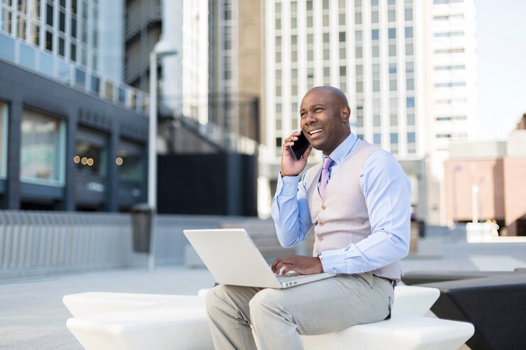 Photo gros plan d'un homme noir entreprenant travaillant avec son ordinateur portable dans la rue.