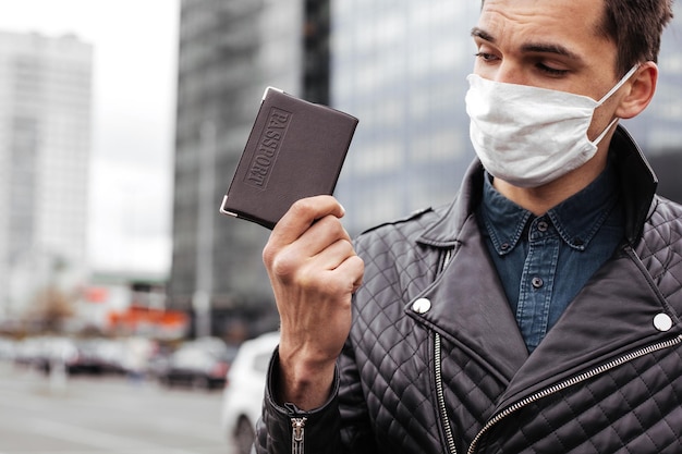 Gros plan sur un homme avec un passeport sur une photo de rue de la ville avec un fond