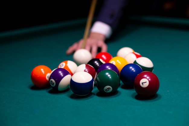 Photo gros plan homme avec queue de billard jouant au billard