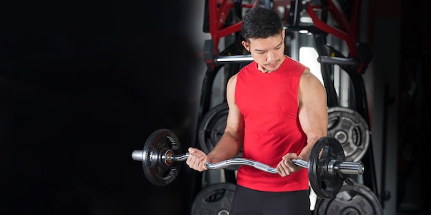 Gros plan de l'homme de remise en forme, haltérophilie d'entraînement beau mec athlétique dans la salle de gym