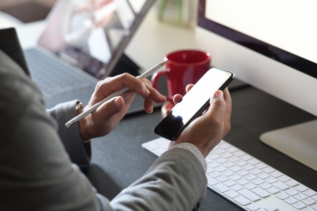 Gros plan d&#39;un homme avec des smartphones au bureau