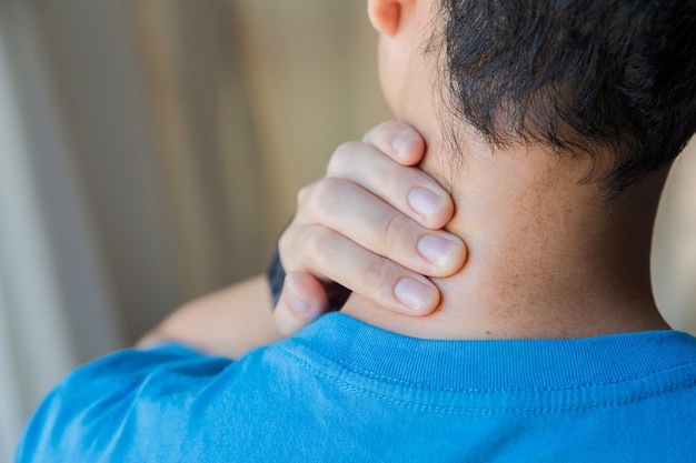 Photo gros plan de l'homme son cou avec la main alors qu'il souffre de douleur dans le cou