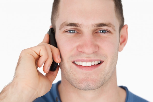 Gros plan d&#39;un homme souriant au téléphone