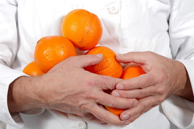 Gros plan d'un homme tenant un brunch d'oranges