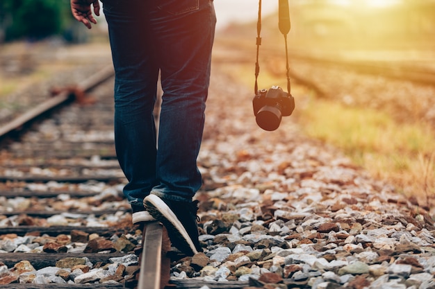 Gros plan d&#39;un homme tenant une caméra numérique à pied dans le train