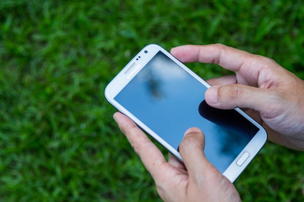 Gros plan homme en utilisant le fond vert de téléphone intelligent mobile