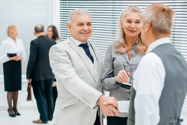 Gros plan sur les hommes d'affaires prospères se serrant la main au bureau