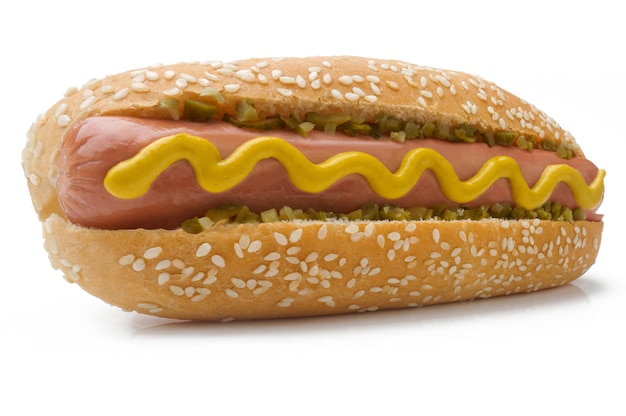Photo gros plan d'un hot-dog avec moutarde et cornichon en perspective sur un fond blanc