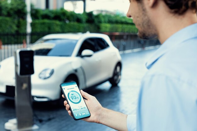 Gros plan idée progressiste hand holding smart phone afficher l'état de la pâte EV