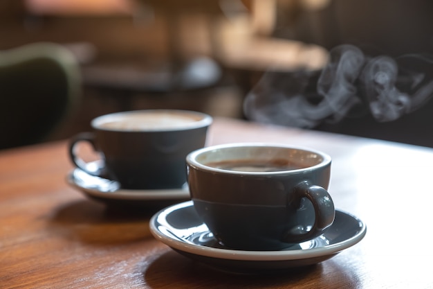 Gros plan image de deux tasses bleues de café chaud sur une table en bois vintage au café