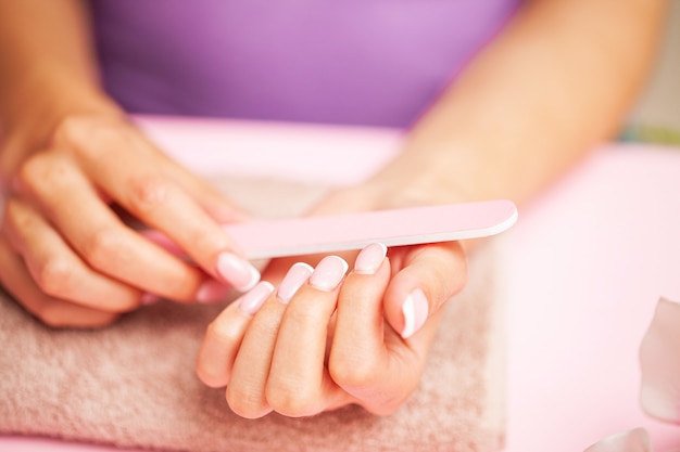 Gros plan image de femme à l'aide de tampon à ongles lors de la manucure, le polissage des ongles à la maison.