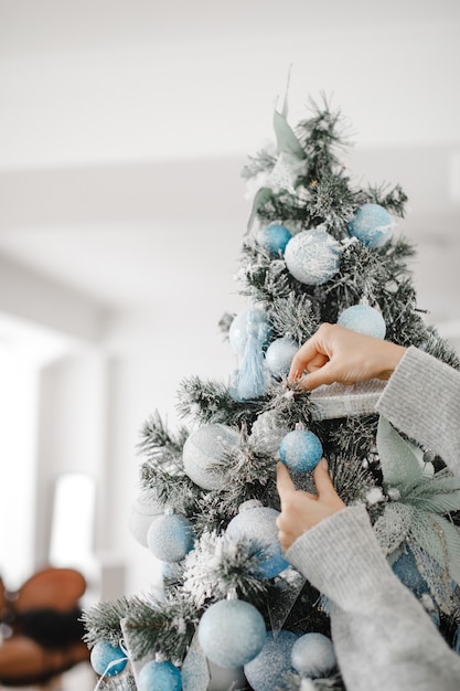 Gros plan image de femme en pull décoration arbre de Noël avec des boules