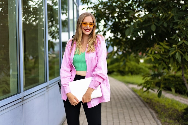 Gros plan sur l'image horizontale d'une femme blonde élégante à l'aide de son ordinateur portable, maquillage lumineux d'humeur positive, de travail et d'étude.