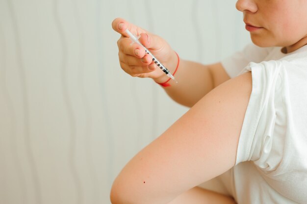 Gros plan sur l'injection d'insuline. Une fille injecte de l'insuline dans sa main de façon indépendante. Diabète
