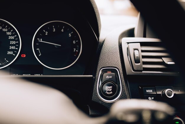 Gros plan de l'intérieur de la voiture avec les détails du bouton de démarrage du moteur voiture hybride électrique moderne