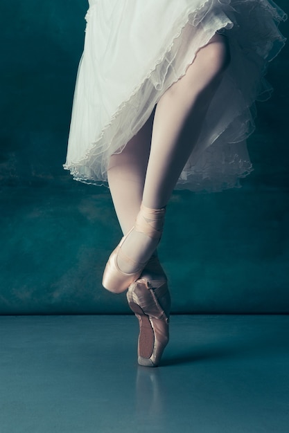 Gros plan des jambes de ballerines classiques en pointes sur le parquet gris. Projet de ballerine avec modèle caucasien. Le concept de ballet, danse, art, contemporain, chorégraphie