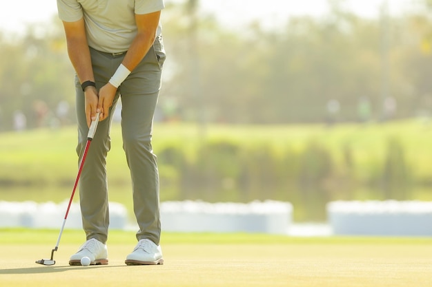 Gros plan sur les jambes du golfeur approcher la balle de golf en mettant sur le concept de mode de vie et de sport vert