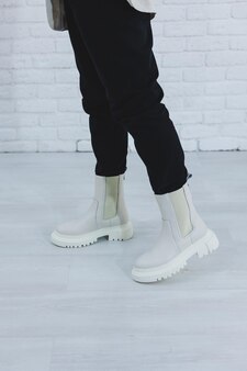 Gros plan des jambes des femmes en bottes d'automne blanches bottes pour femmes en cuir véritable