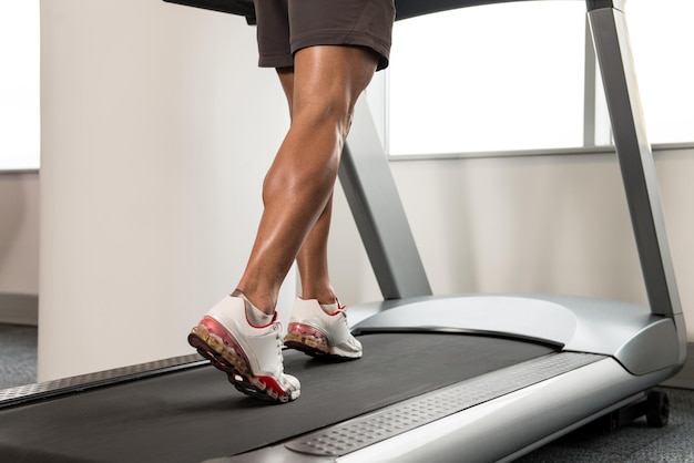 Gros plan des jambes mâles en cours d'exécution sur tapis roulant Blurred Motion