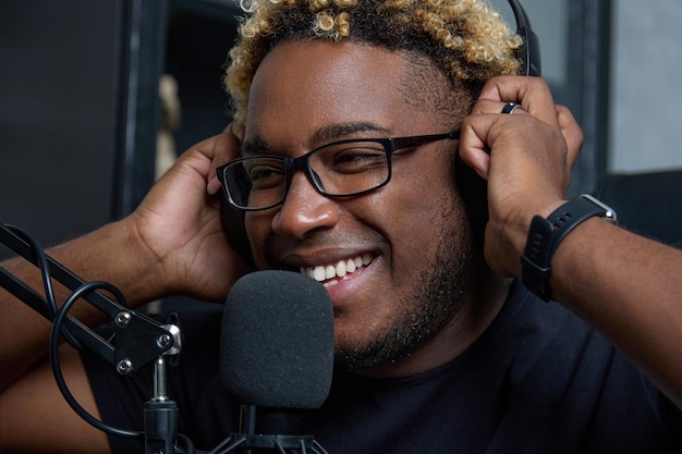 Gros plan d'un jeune blogueur souriant dans un studio d'enregistrement avec