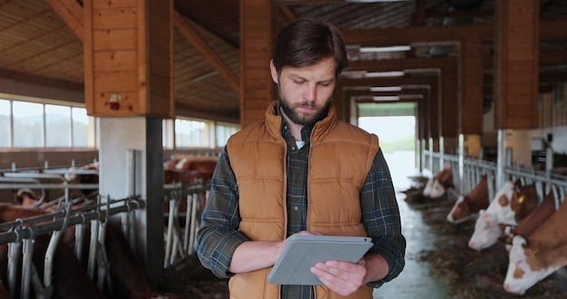 Gros plan, jeune, caucasien, gilet orange, utilisation, tabletPC, travail, ferme