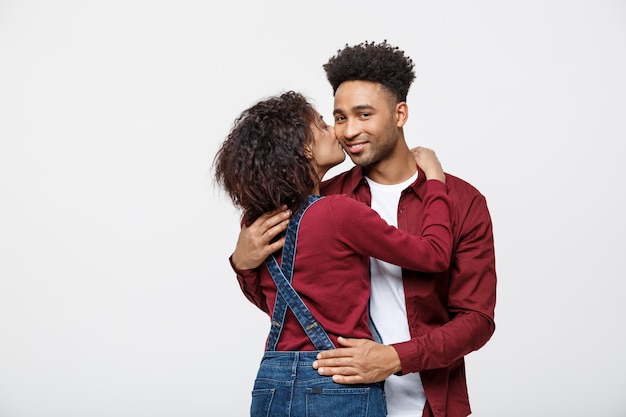 Gros plan de jeune couple afro-américain s&#39;embrasser sur studio de fond blanc