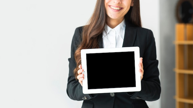 Photo gros plan d'une jeune femme d'affaires montrant une tablette numérique à écran tactile