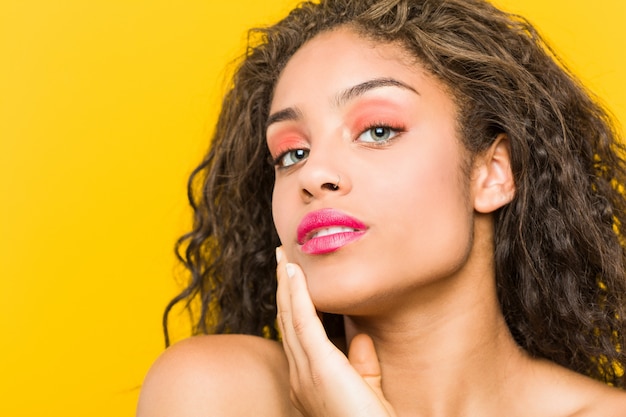 Gros plan d'une jeune femme afro-américaine belle et maquillage posant