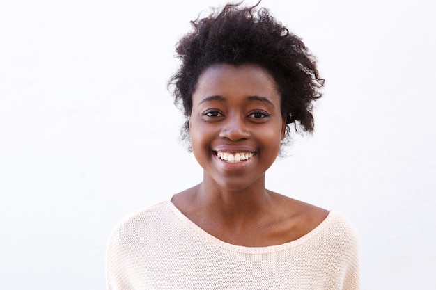 Gros plan jeune femme afro-américaine, souriant sur fond blanc