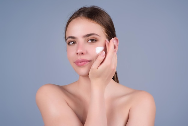 Gros plan jeune femme appliquant de la crème pour faire face aux soins de la peau et aux cosmétiques concept de soins de la peau fille appliquant cr