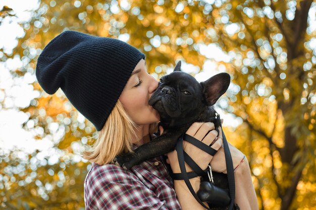 Gros plan sur une jeune femme heureuse avec un chien à l'extérieur en automne