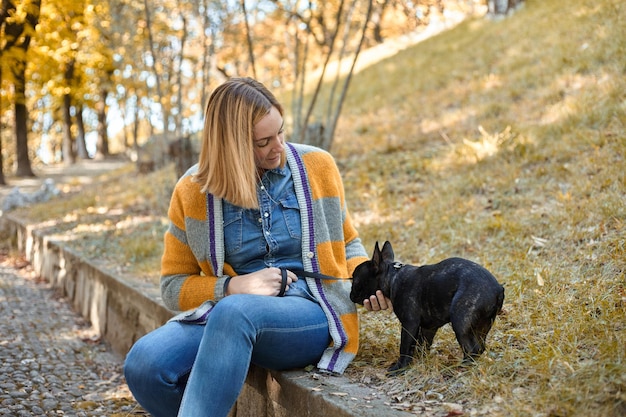 Gros plan sur une jeune femme heureuse avec un chien à l'extérieur en automne