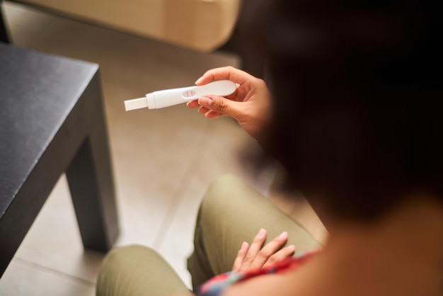 Photo gros plan d'une jeune femme latine regardant un test de grossesse positif maternité planification familiale