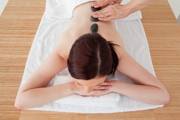 Gros plan d&#39;une jeune femme séduisante aux cheveux roux recevant un massage dans un centre de spa