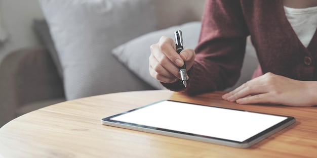 Gros plan d'une jeune femme utilisant la technologie du stylo intelligent pour travailler et écrire sur l'écran d'une tablette numérique