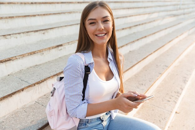 Gros plan d'une jeune fille joyeuse avec sac à dos