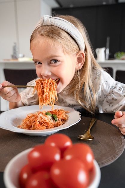 Photo gros plan sur une jeune fille mangeant des pâtes