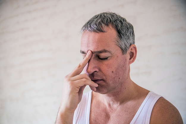 Gros plan, jeune homme adulte, tristement déprimé, stressé, seul, déçu, sombre, face à la main. Jeune homme frustré jeune homme épuisé