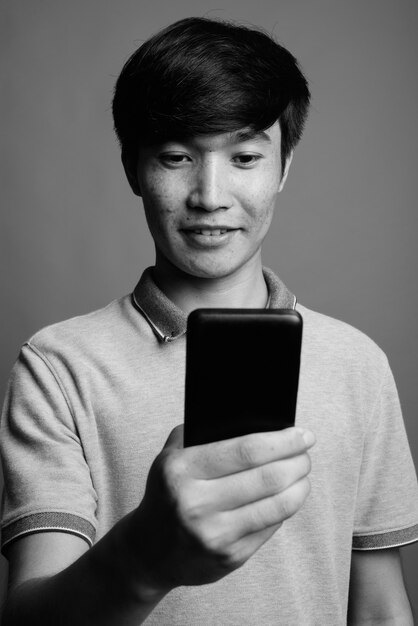 Gros plan, de, jeune homme asiatique, utilisation, téléphone portable