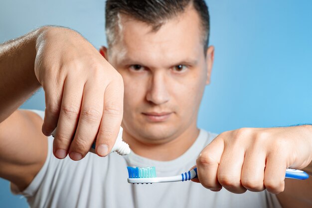 Gros plan d'un jeune homme attrayant se brosser les dents.